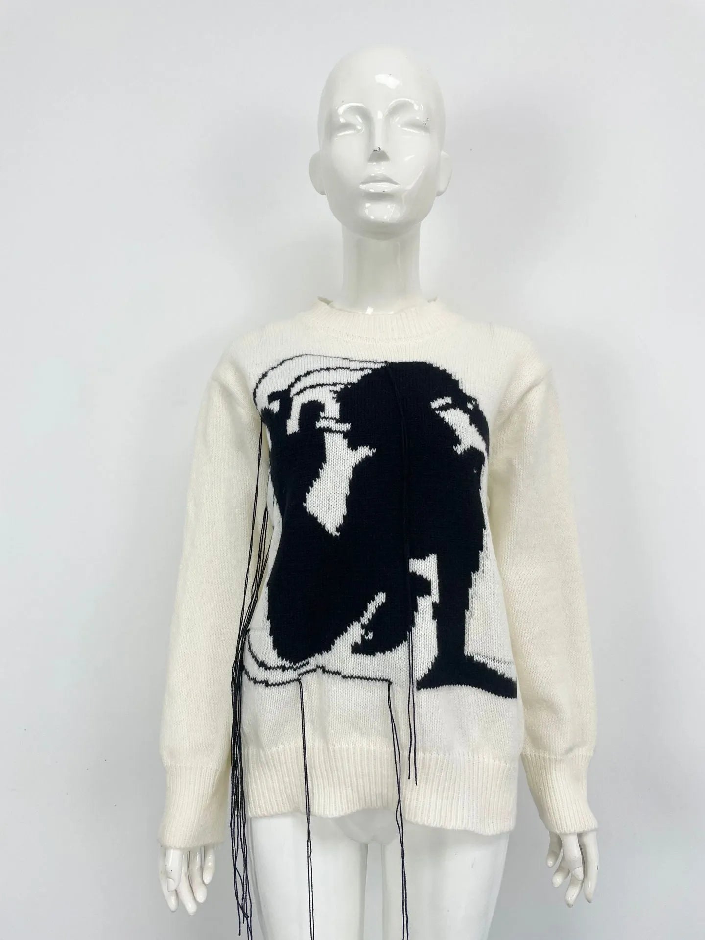 Grey women's loose alpaca wool sweater with tassel detail and abstract pattern, round neck.