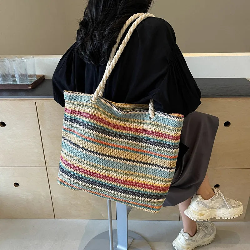 Blue straw woven nylon shoulder bag with a single strap and large main compartment