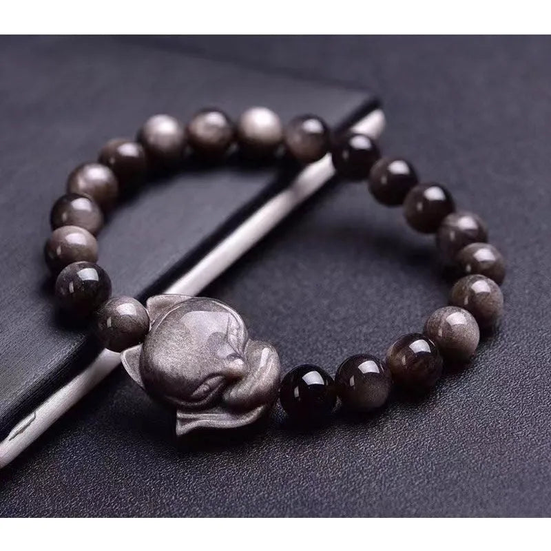 Close-up of a women's adjustable bracelet with a dark obsidian fox bead and sliding knot.