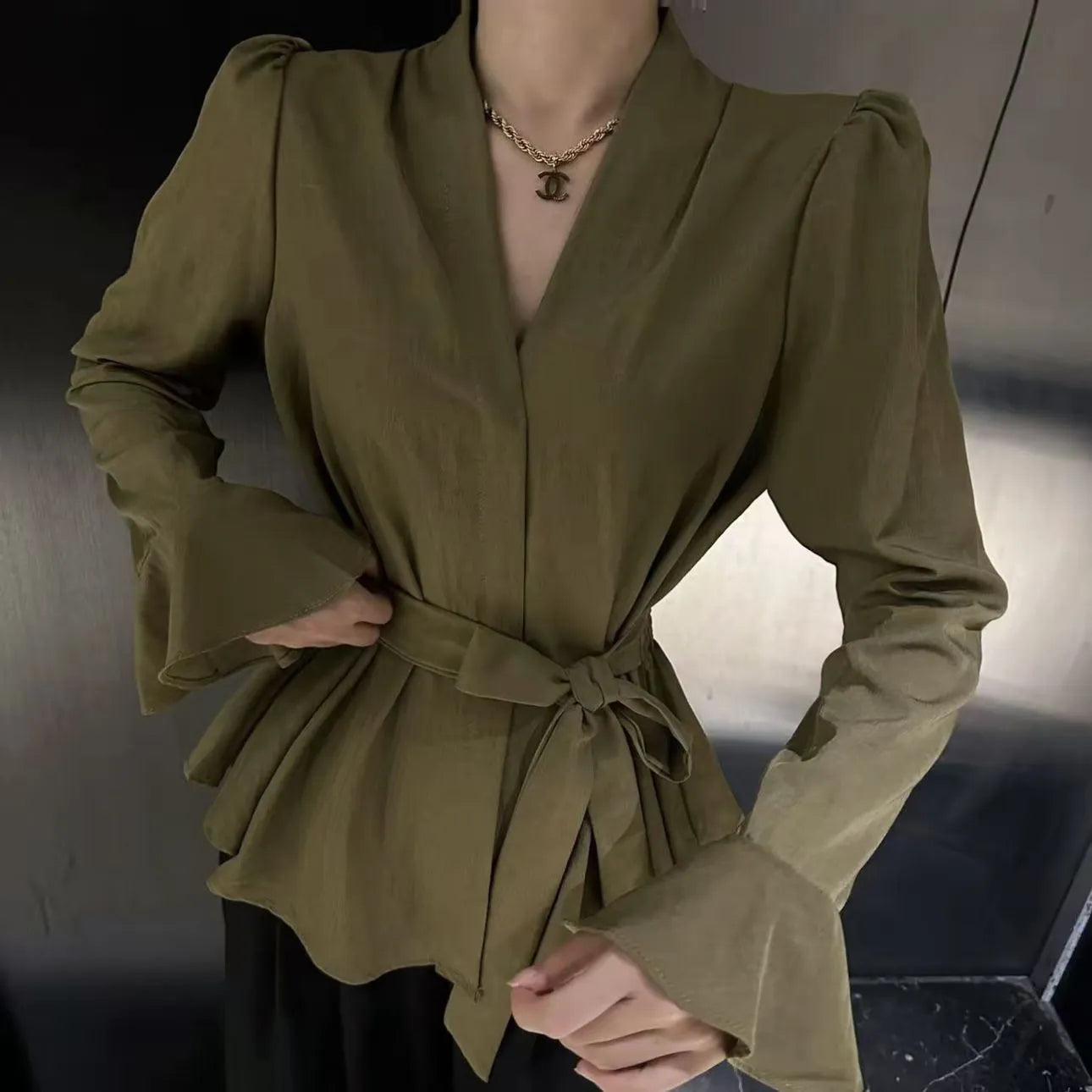 Women's black French-style shirt with irregular collar, long bell sleeves, and a tied front detail.