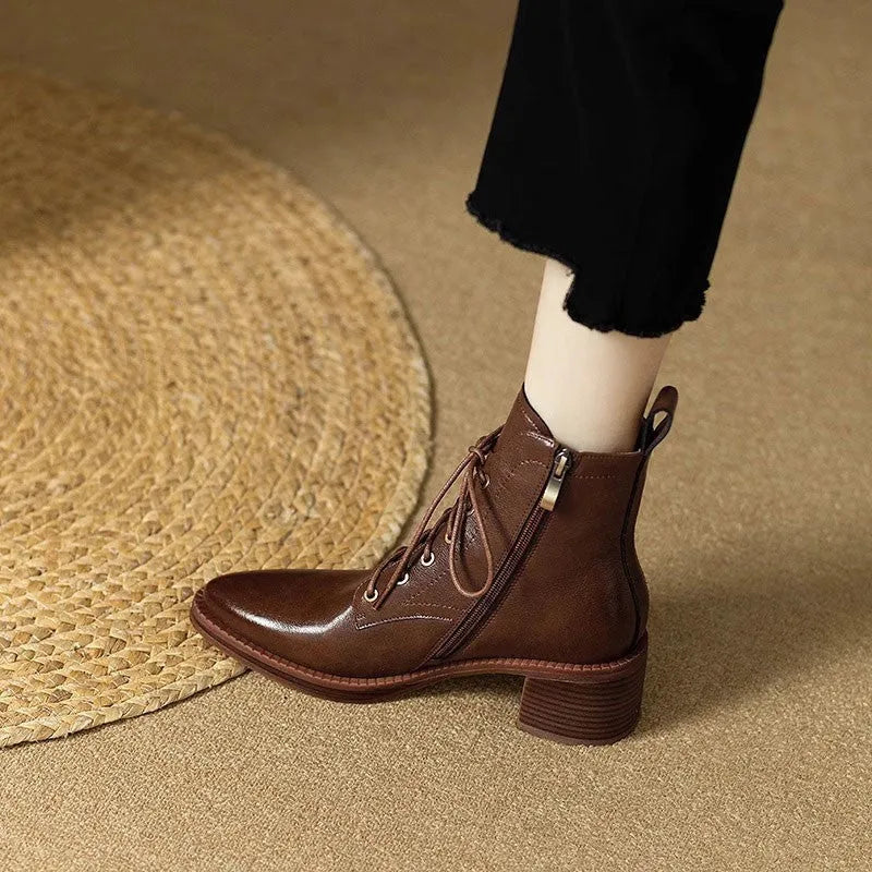 Women's black pointed-toe short tube boots with a 5.5cm heel on a plain background.