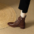 Women's black pointed-toe short tube boots with a 5.5cm heel on a plain background.