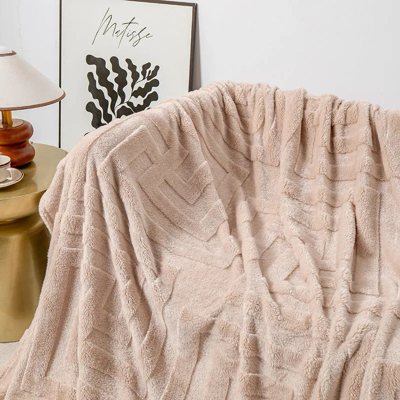 Thick square coral fleece blanket in a solid colour, draped over a sofa.