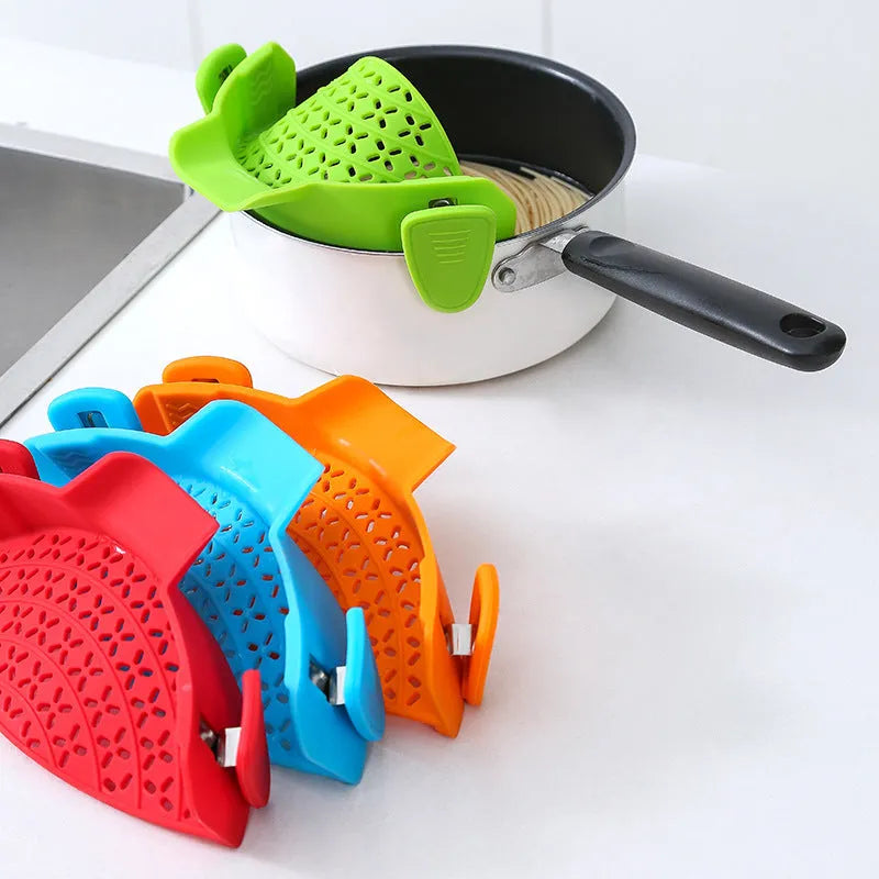 Silicone pot side drain stopper in black attached to saucepan rim with leak-proof edge