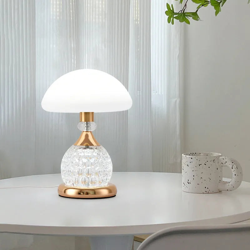 Light luxury mushroom table lamp with carved base in transparent colour on a wooden bedside table