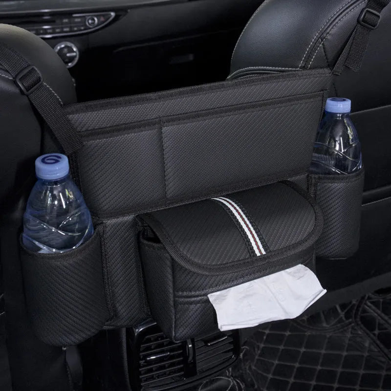 Black leather car interseat storage bag holding a tissue box, hanging between vehicle front seats.