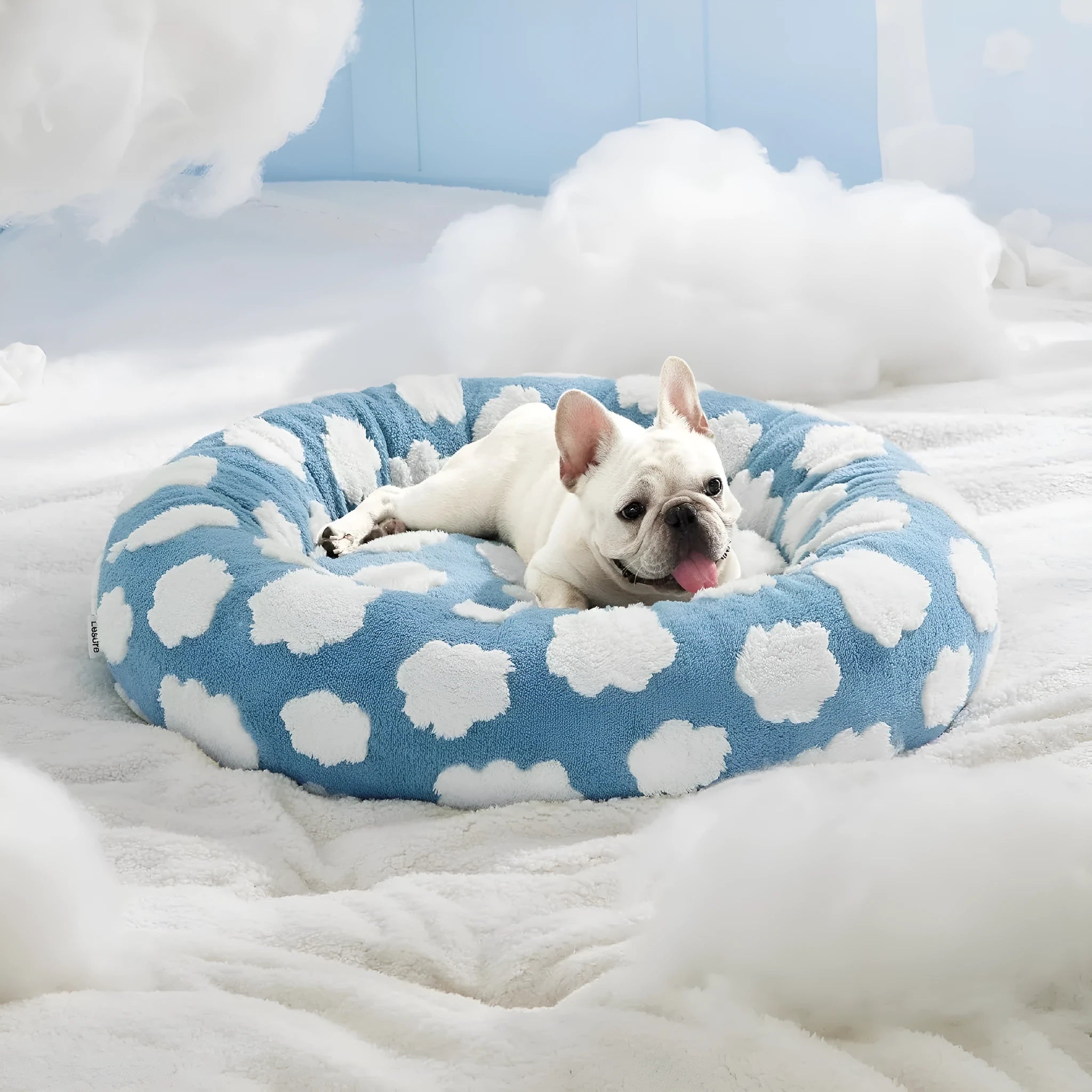Round plastic dog bed with a blue and white plaid fabric cover, shown on a wooden floor.