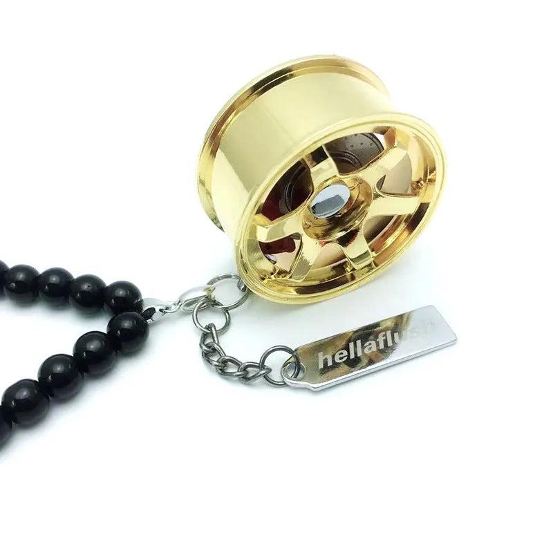Stainless steel car tyre ornament with crystal glass bead chain hanging from a rearview mirror