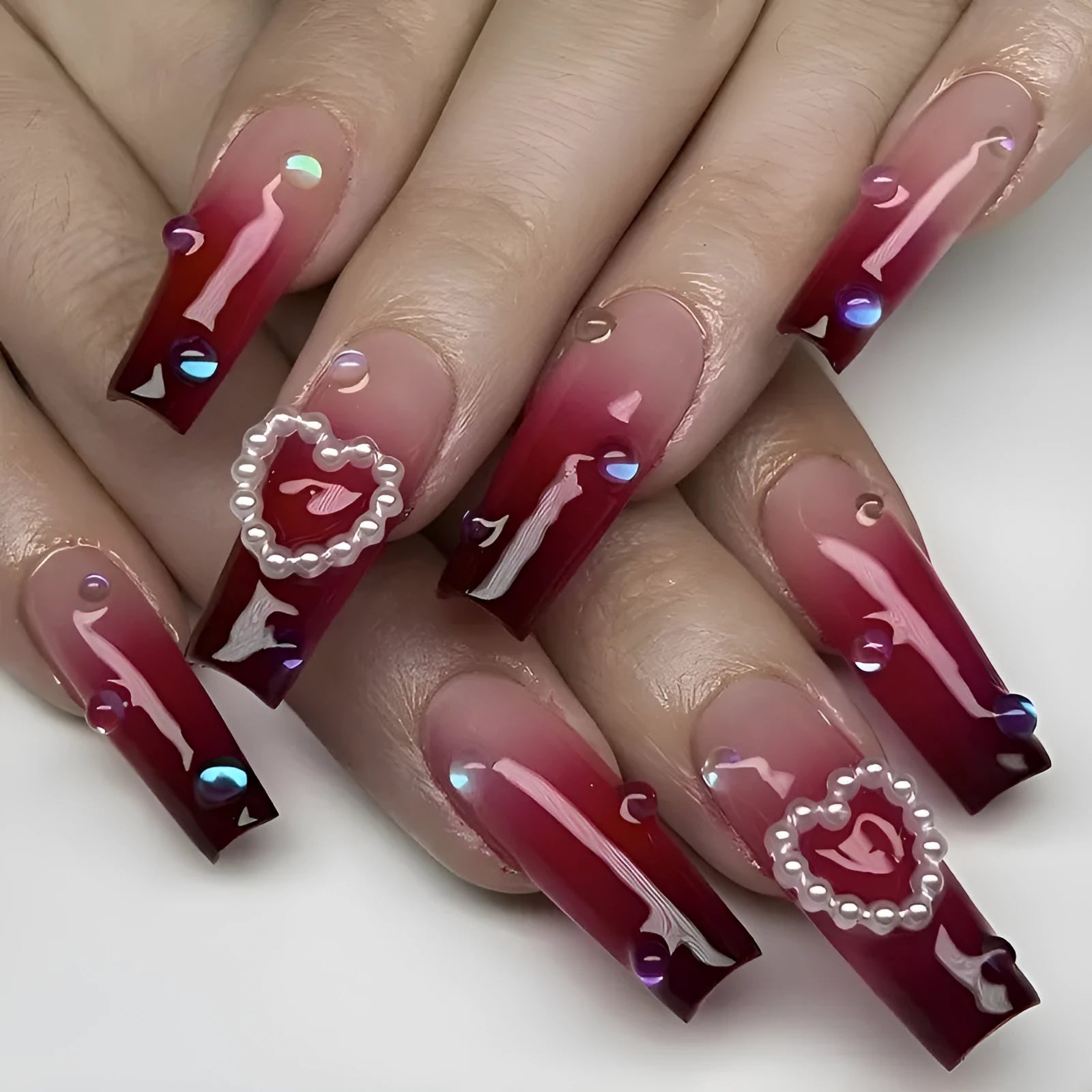 Wine red gradient fake nail tips with plaid pattern in long ballet style displayed with jelly glue applicator