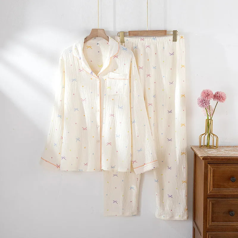 Women's pink cotton long-sleeve pajama top and trousers set laid flat.