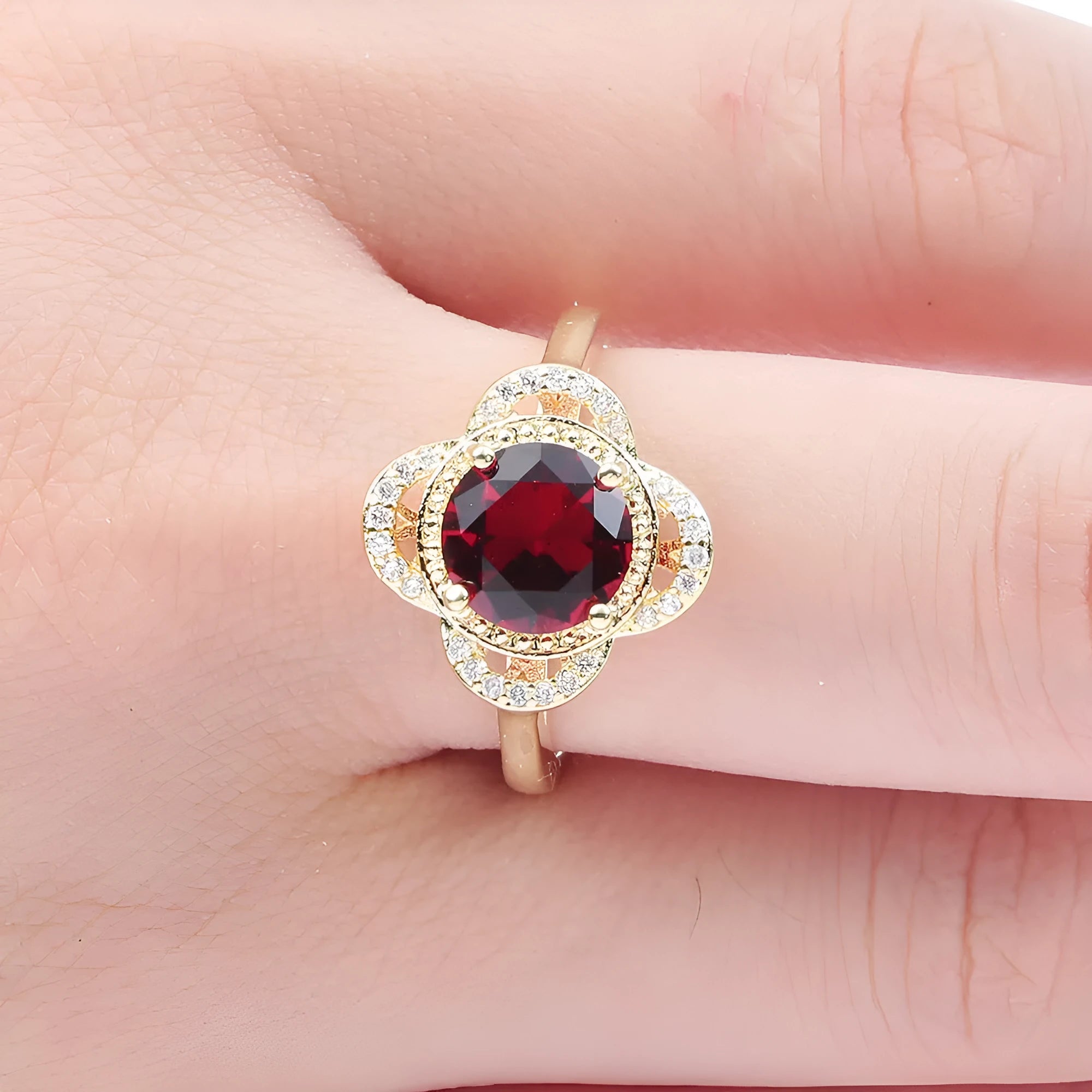 Copper zircon ring with a fruit-shaped design on a finger.