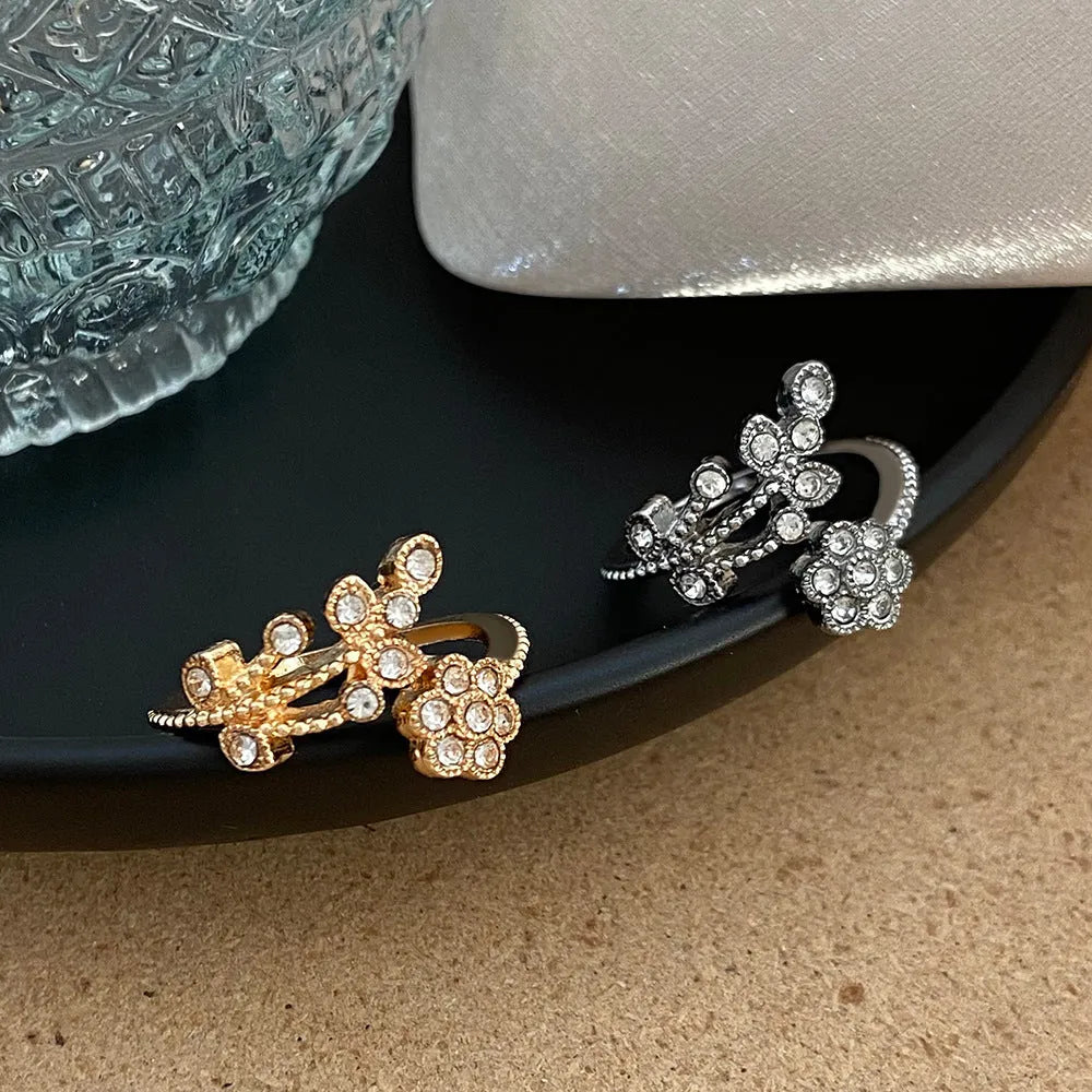 Women's open ring with floral leaf design in gold tone on white background