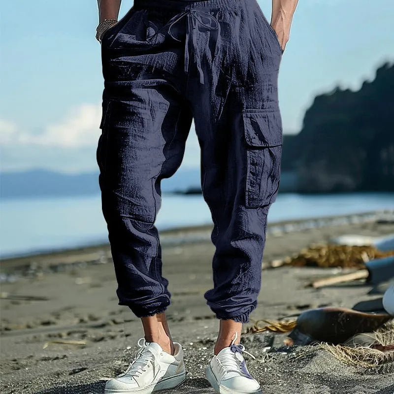 Man wearing khaki linen casual trousers with ankle-tied legs and multiple pockets.