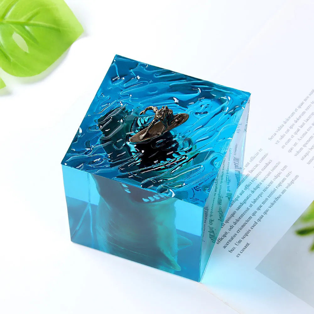 Close-up of a crystal resin shark surfer night light ornament on a dark surface.
