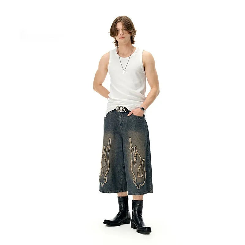 Men's black denim shorts with flame embroidery and patch detailing in straight cut design