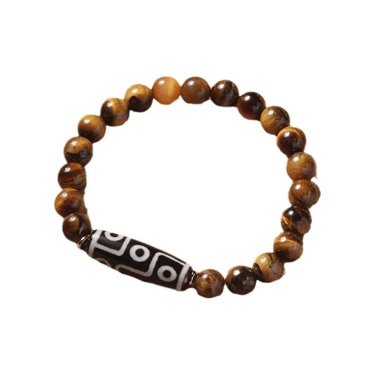 Single Tigereye Dzi bead Buddha rosary bracelet on wrist, showing simple ethnic design.
