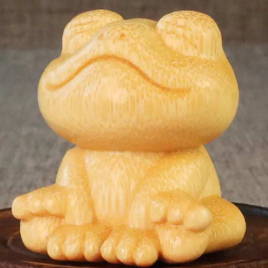 Solid bamboo carving of a cartoon smiling frog ornament, 5cm tall.