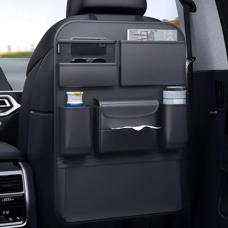 Black leather car seat back hanging storage organiser bag with handle shown mounted on a headrest.