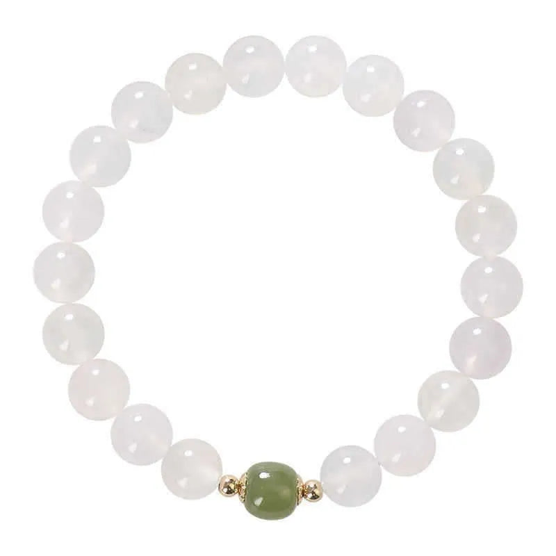 Handmade white agate and cinnabar bracelet with text design on a wrist.