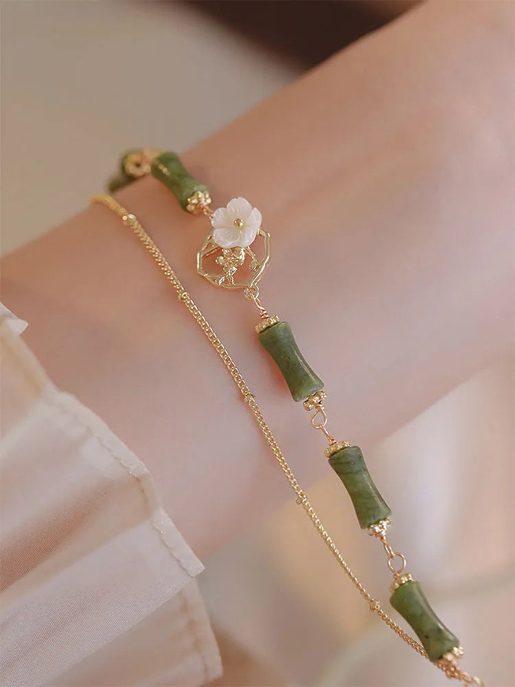 Natural olivine gemstone bracelet for women with double layer design and twin bells of Ireland charms.