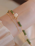 Natural olivine gemstone bracelet for women with double layer design and twin bells of Ireland charms.