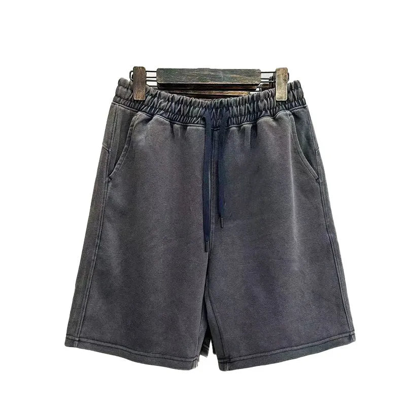 Men's solid colour cotton shorts with distressed detailing on the leg, shown in a loose, straight-leg fit.