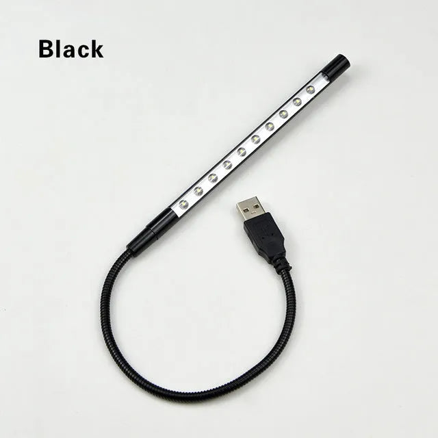 Black aluminium alloy spiral USB LED night light on a desk next to a laptop