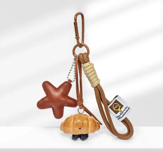 Handmade resin handbag pendant with soda bread designs including cartoon croissant and brown stars