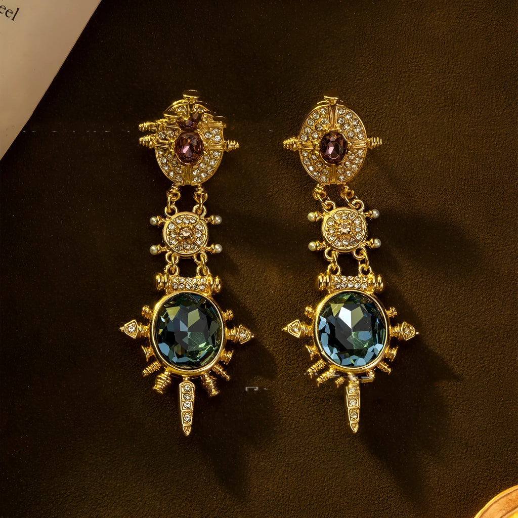 A pair of gold geometric round stud earrings with a diamond-treated finish on a white background.