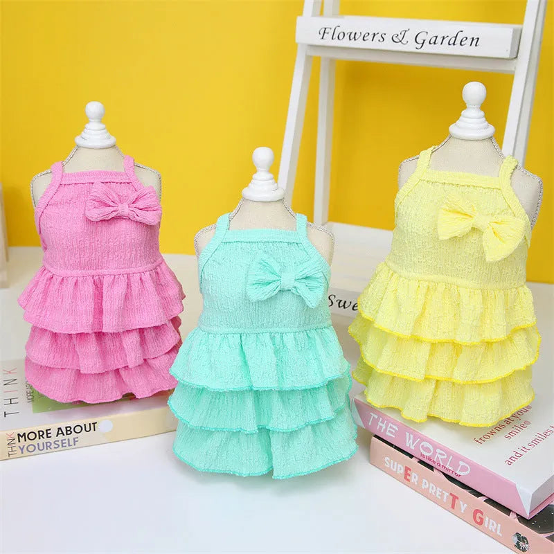 Small dog wearing a layered princess dress in a candy skirt style, available in rose red, yellow, or green.