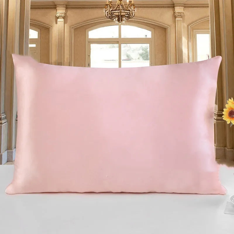 19 M double-sided silk pillowcase in apricot colour on a bed.