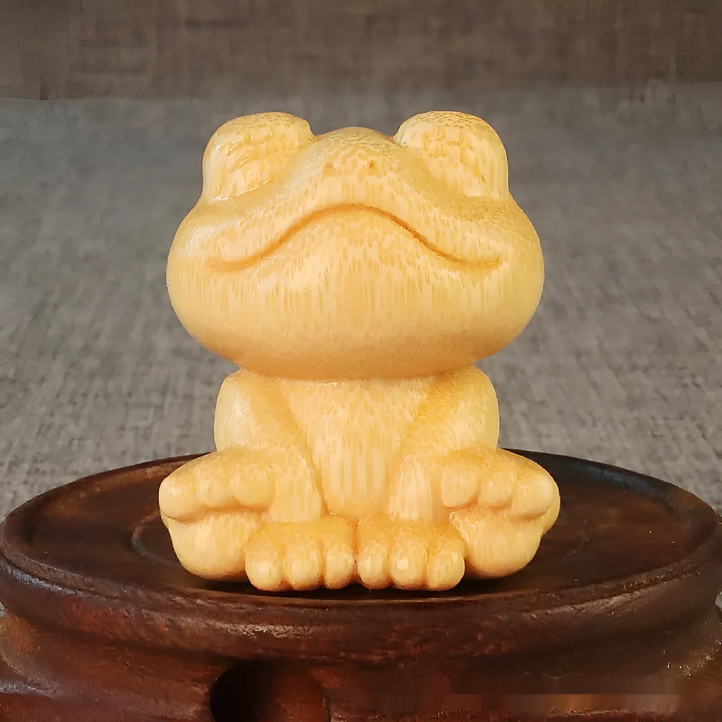 Solid bamboo carving of a cartoon smiling frog ornament, 5cm tall.