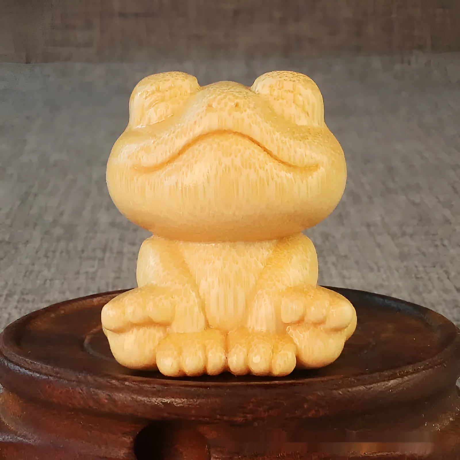 Solid bamboo carving of a cartoon smiling frog ornament, 5cm tall.