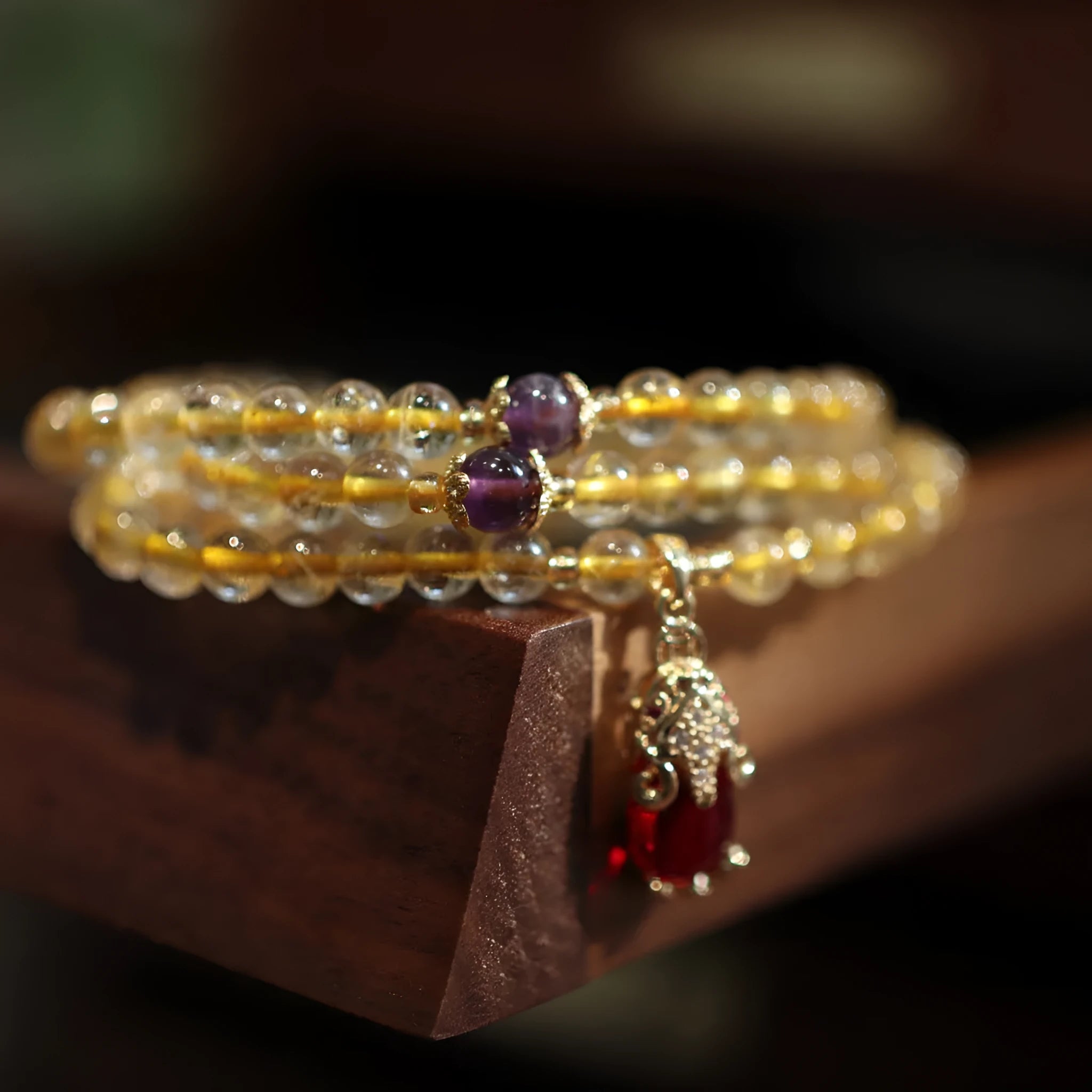 Handmade gold and ruby quartz Chinese bracelet with three circles and hanging chopstick detailing