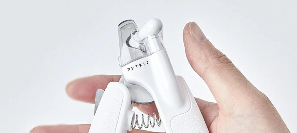 White pet nail clippers with LED light and a transparent anti-splash guard, shown with a nail file.