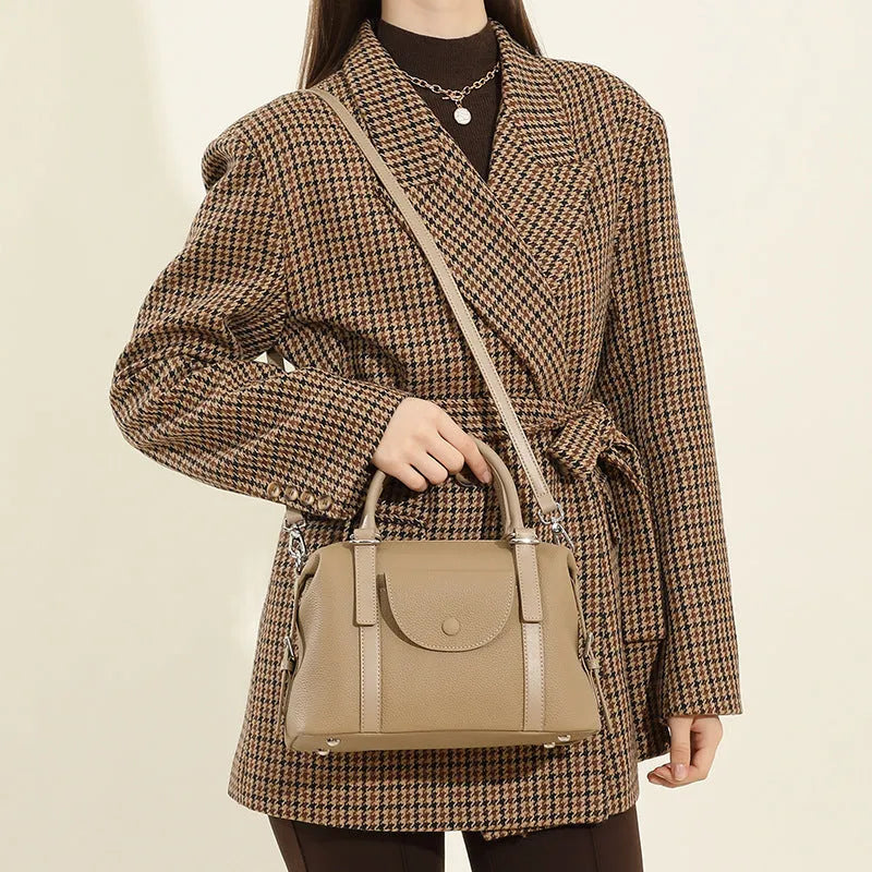Genuine leather ladies handbag in street trend style with contrast stitching and lock detail.