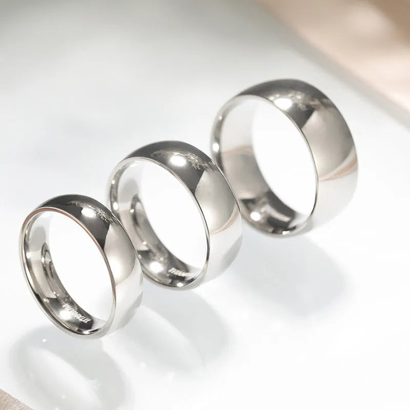 Silver titanium steel ring on a finger, showing a simple band design.