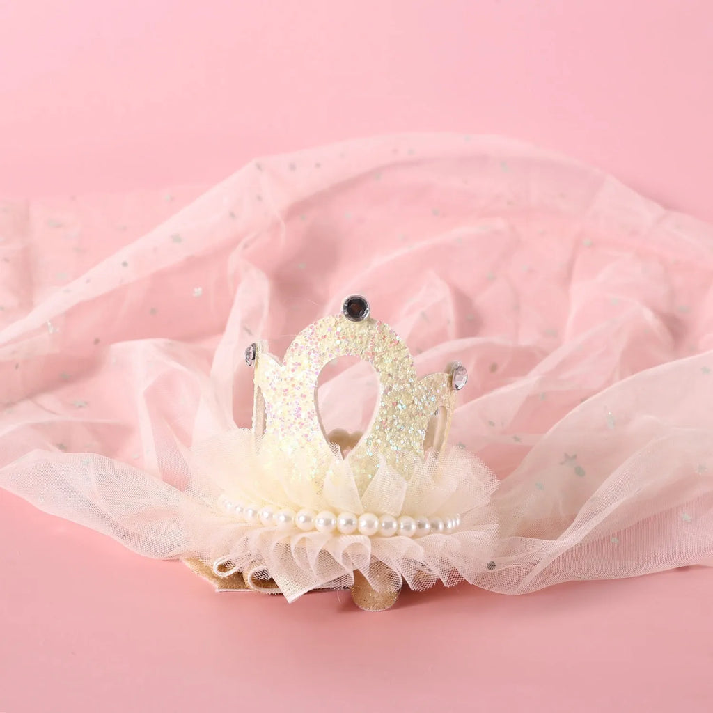 A cat wearing a princess crown headdress with a long, flowing veil for a wedding or celebration.