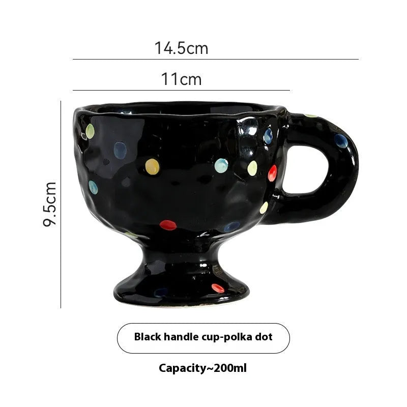 Hand-pinched irregularly shaped ceramic mug in a solid colour, shown on a table.
