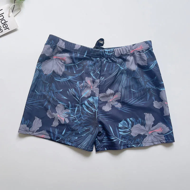 Men's loose-fit polyester swim trunks in dark blue with large flower print, three sizes available