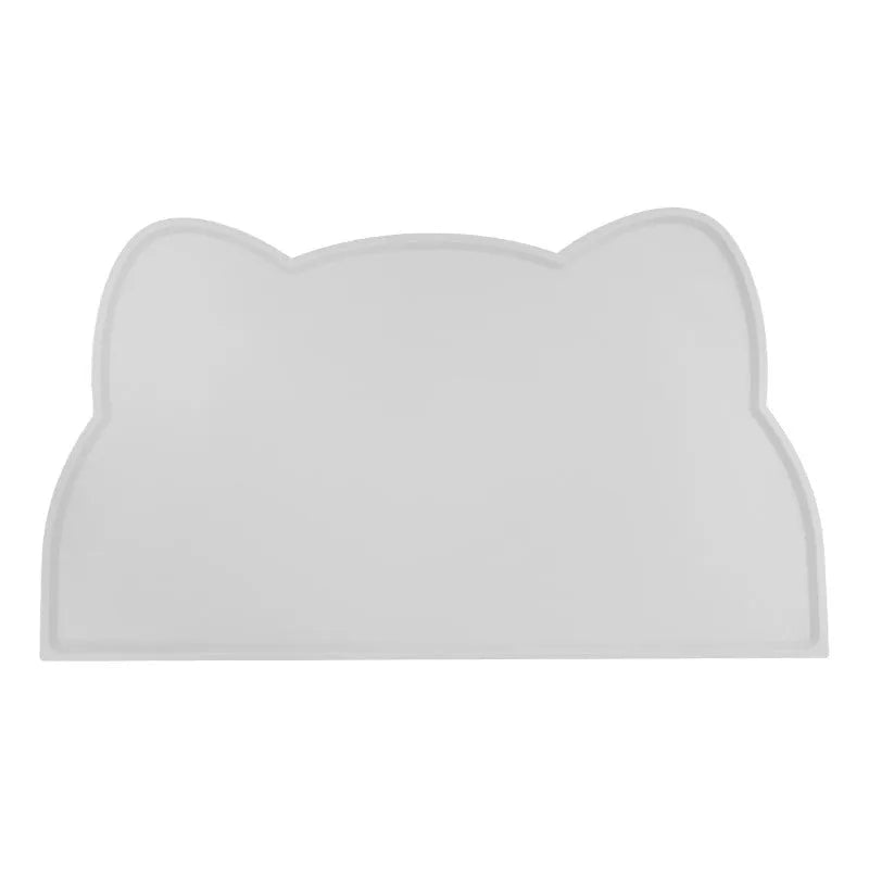 Blue silicone cat head-shaped pet feeding mat on a wooden floor.