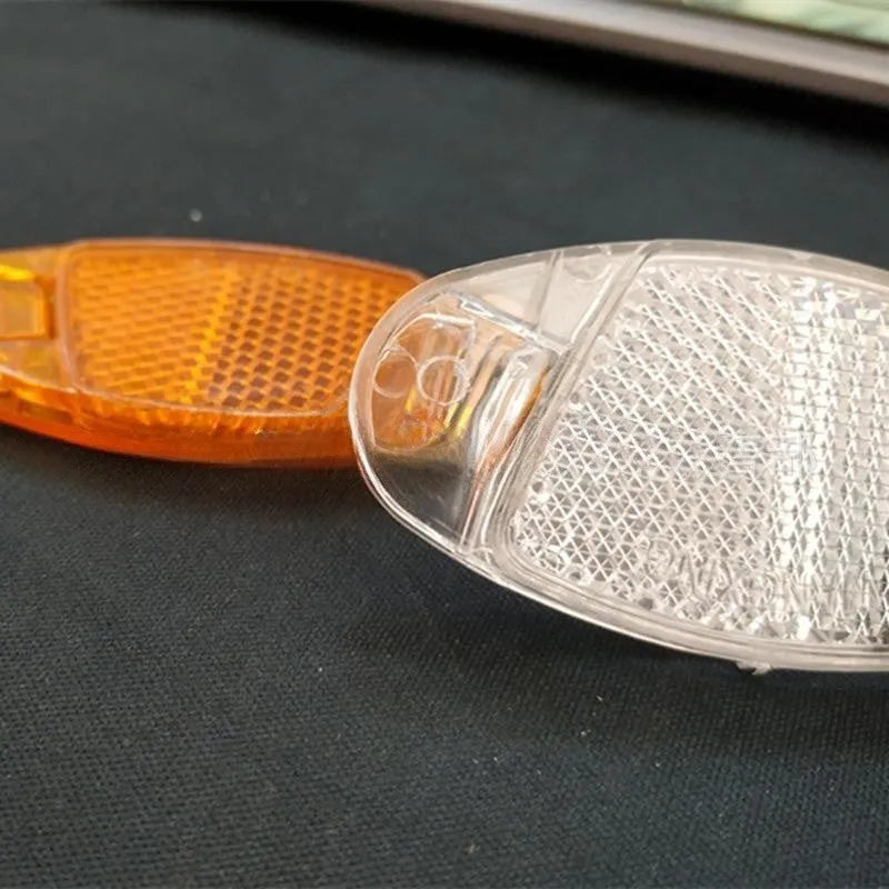 White and yellow plastic bicycle wheel spoke reflectors showing dimensions