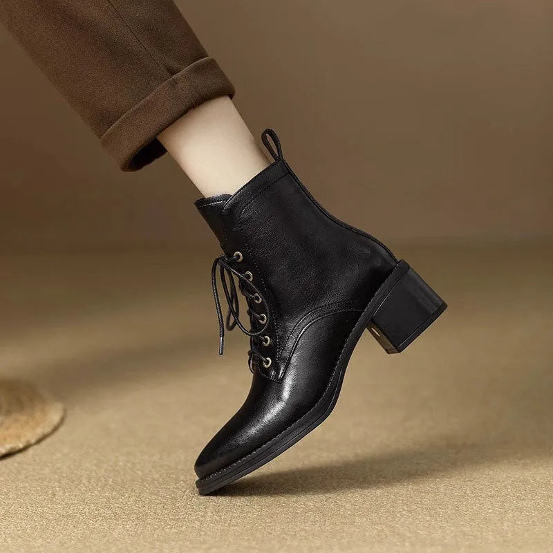 Women's black pointed-toe short tube boots with a 5.5cm heel on a plain background.
