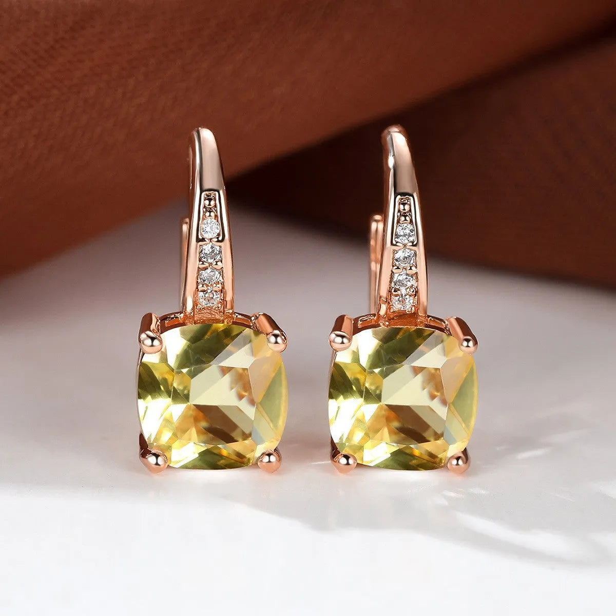 Square geometric ear hook studs with a round zircon stone, shown in a gold electroplated finish.