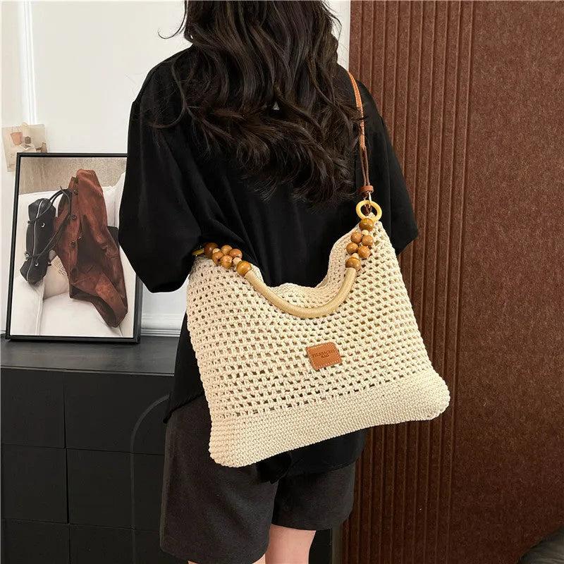 Knitted tote beach bag with contrast stitching showing crossbody strap and zip compartment