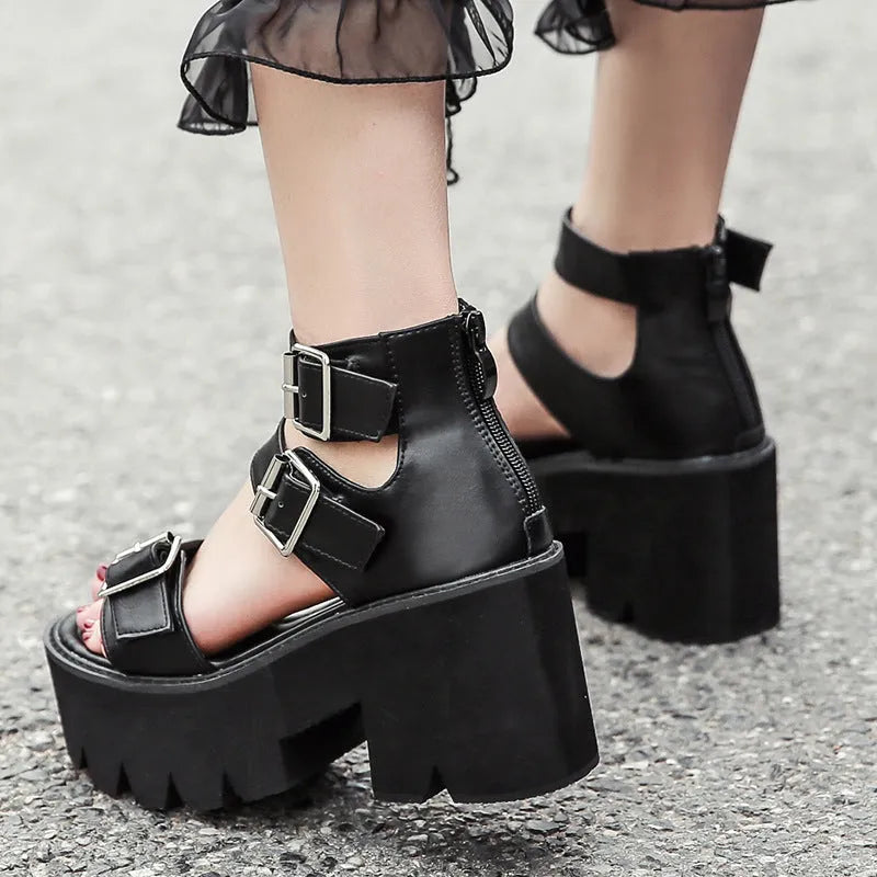 Black women's punk-style sandals with chunky heel, round toe, back zipper, and decorative buckle.