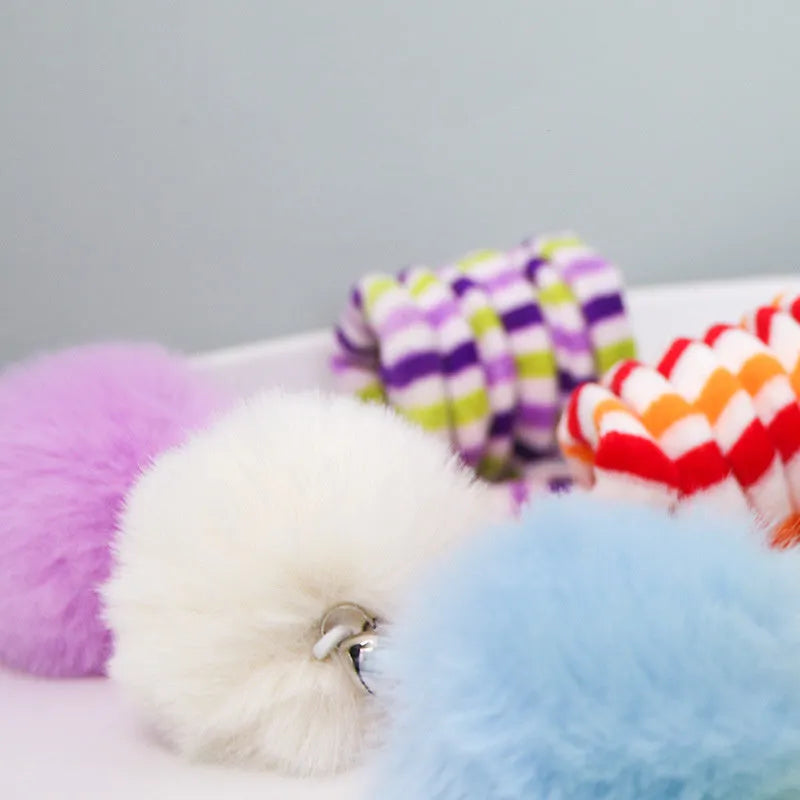 Colourful spring cat toy with hanging bell stick and inflatable ball, shown with a white suction cup.