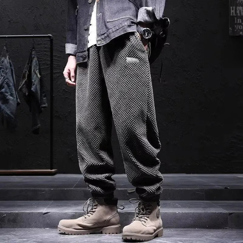 Men's grey ankle-tied straight leg sweatpants laid flat on a surface.