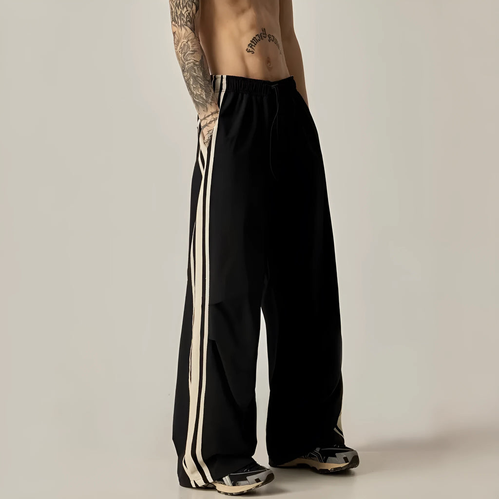 Man wearing black high-waisted straight-leg casual climbing trousers.