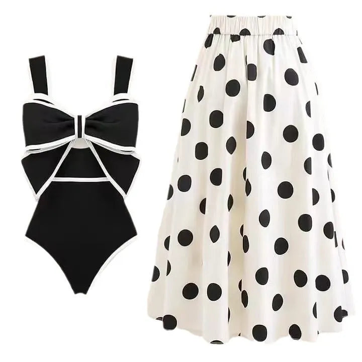 Women's black one-piece swimsuit with a white bow and attached round skirt.